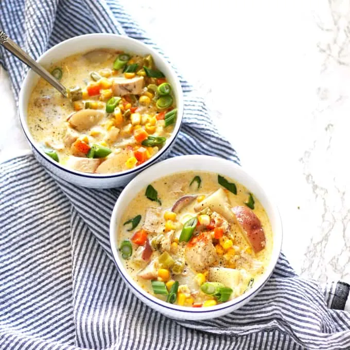 chicken corn chowder in two bowls on a napkin