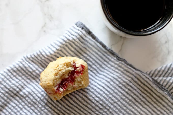muffin with vein of jam and a cup of coffee