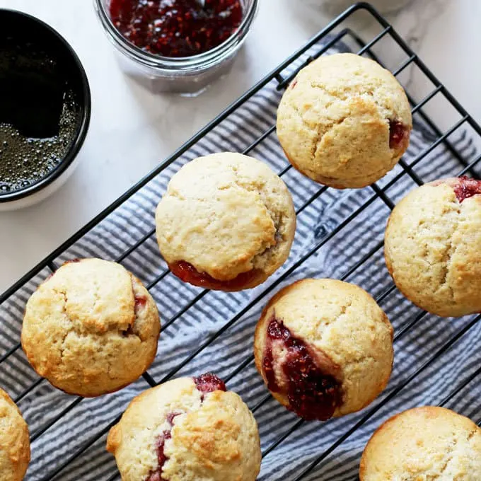 These easy muffins filled with jam are the perfect quick breakfast! I like to eat one or two in the morning with a piping hot cup of coffee. It's such an easy recipe to make that you can make a batch when you wake up. Also, they are perfect for farmer's market preserves and jams! | honeyandbirch.com