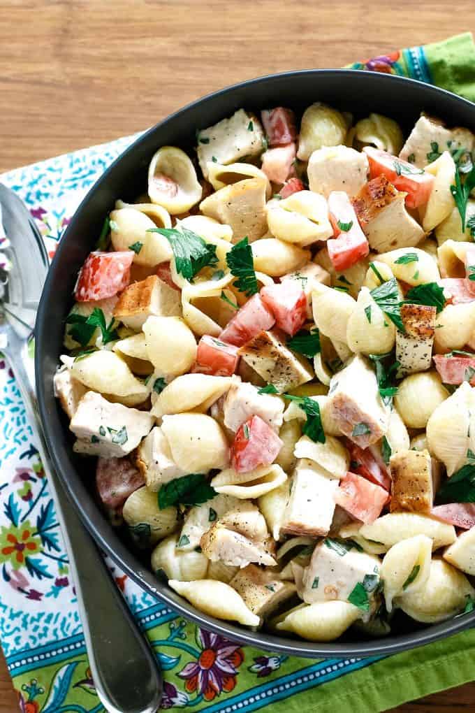 bowl of grilled chicken ranch pasta salad on a wooden board