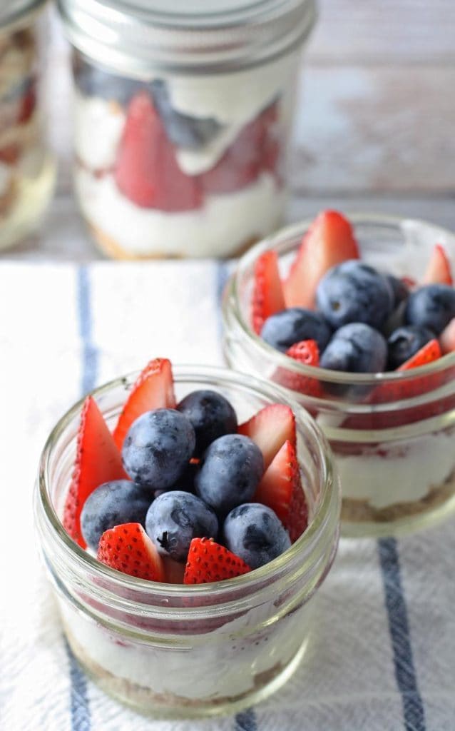 red white and blue cheesecake parfait recipe in small mason jars
