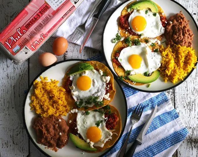 This huevos rancheros recipe is a delicious way to start your day! Made with homemade salsa and fresh eggs, it is hearty, easy to make, vegetarian, and perfect for weekend brunch or large family gatherings. Serve with a side of refried beans and rice! | honeyandbirch.com