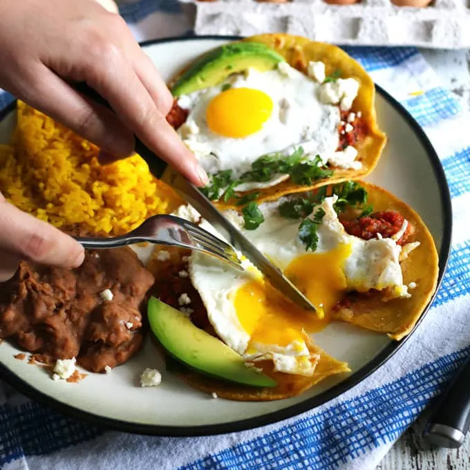 This huevos rancheros recipe is a delicious way to start your day! Made with homemade salsa and fresh eggs, it is hearty, easy to make, vegetarian, and perfect for weekend brunch or large family gatherings. Serve with a side of refried beans and rice! | honeyandbirch.com