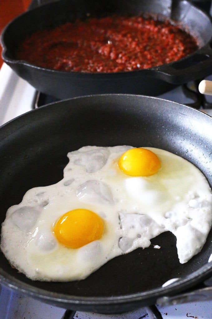 two eggs frying in a pan