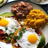 This huevos rancheros recipe is a delicious way to start your day! Made with homemade salsa and fresh eggs, it is hearty, easy to make, vegetarian, and perfect for weekend brunch or large family gatherings. Serve with a side of refried beans and rice! | honeyandbirch.com