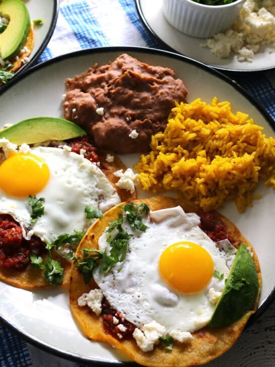 This huevos rancheros recipe is a delicious way to start your day! Made with homemade salsa and fresh eggs, it is hearty, easy to make, vegetarian, and perfect for weekend brunch or large family gatherings. Serve with a side of refried beans and rice! | honeyandbirch.com