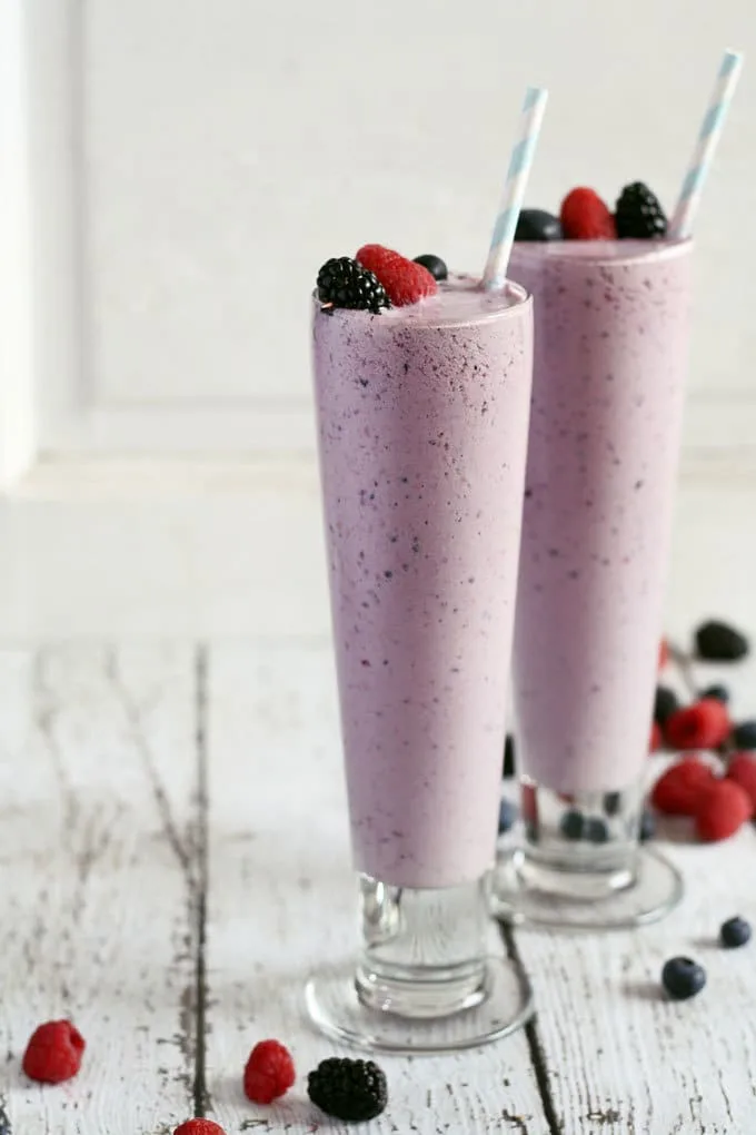 two mixed berry milkshakes in a white board