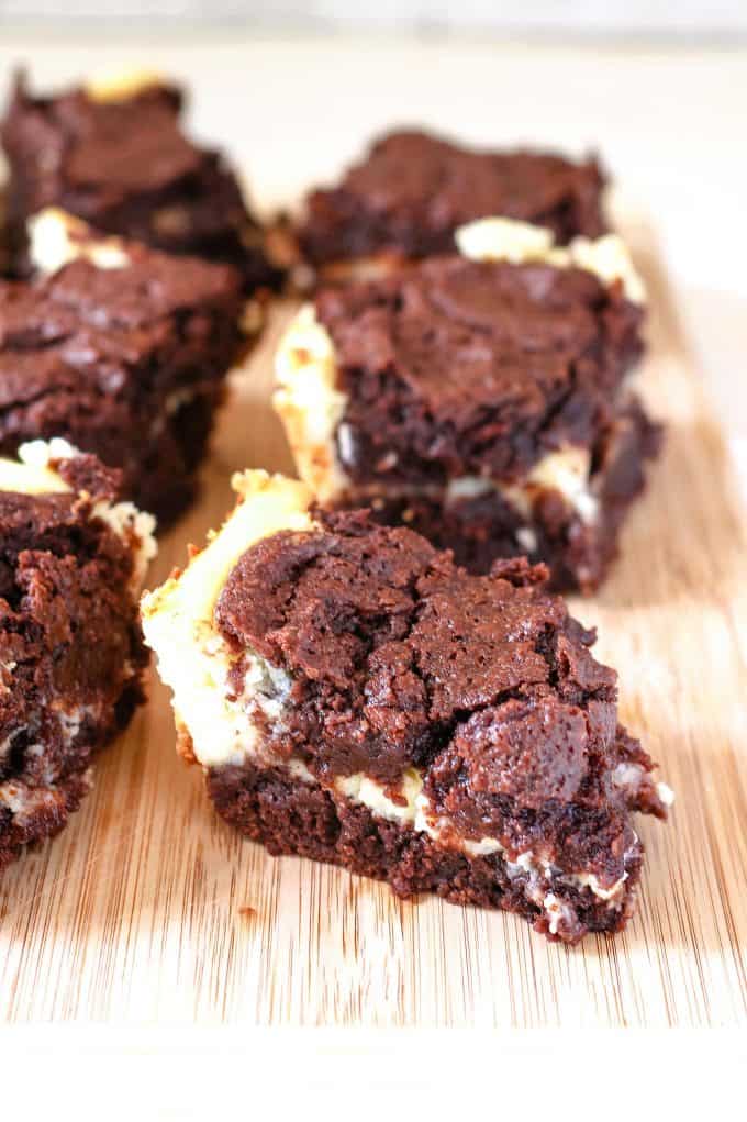 cream cheese brownies on a wooden cutting board