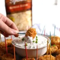 Dip these baked loaded mashed potato tater tots into my creamy loaded potato dipping sauce. They are the perfect healthier way to use leftover mashed potatoes! | honeyandbirch.com