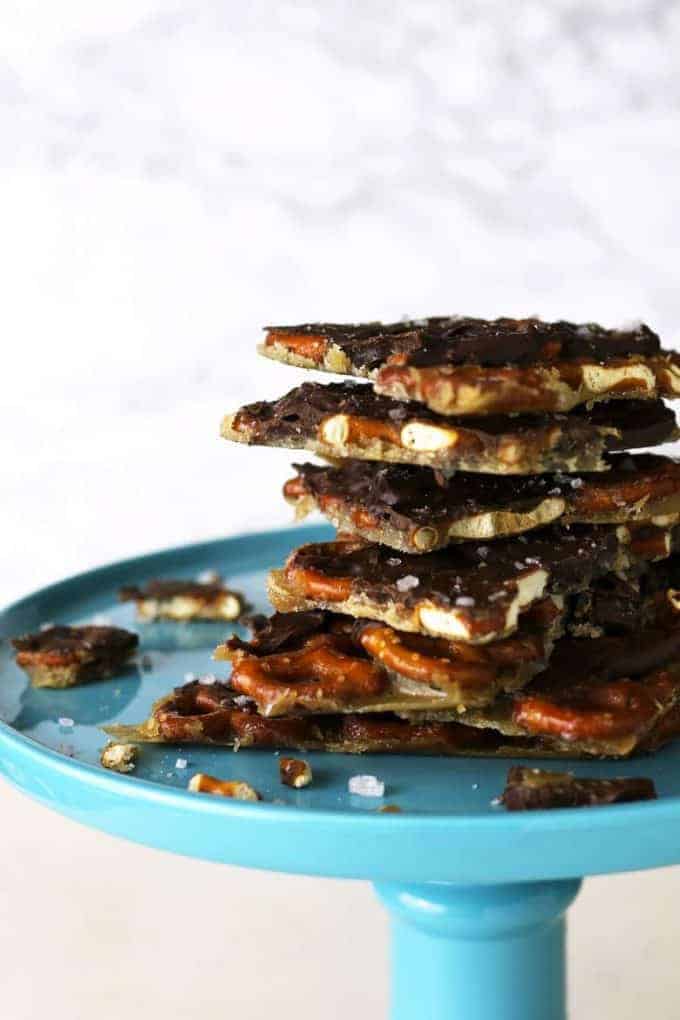 Salted caramel chocolate pretzel bark on a blue cake stand