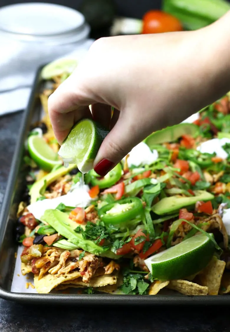squeezing lime juice on chicken nachos