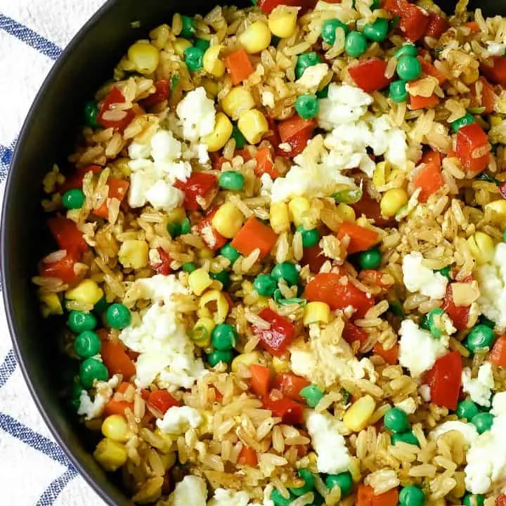 bowl of vegetable fried rice and a blue and white napkin