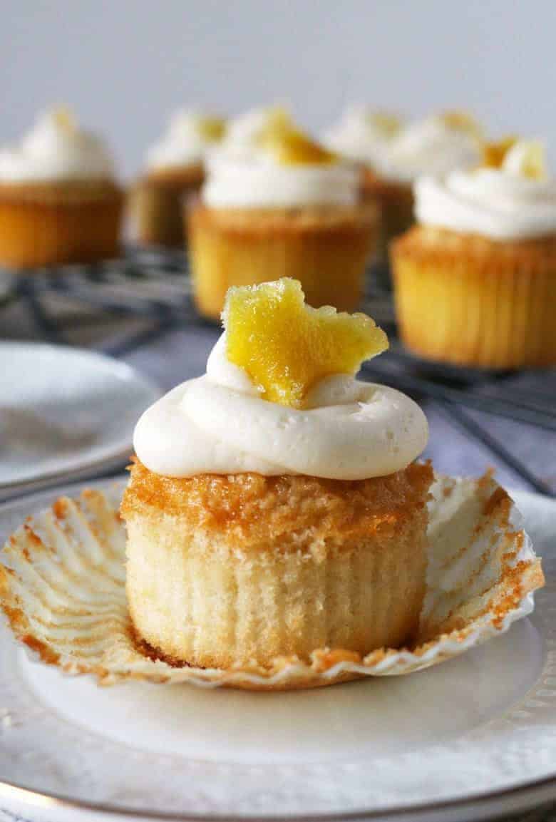 These white cupcakes with lemon frosting are filled with lemon curd and topped with candied lemon peel. They're the perfect sweet treat! This homemade cupcake recipe is easy to make and you can't go wrong with a filled cupcake topped with a fancy decoration!