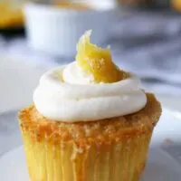 These white cupcakes with lemon frosting are filled with lemon curd and topped with candied lemon peel. They're the perfect sweet treat! This homemade cupcake recipe is easy to make and you can't go wrong with a filled cupcake topped with a fancy decoration!