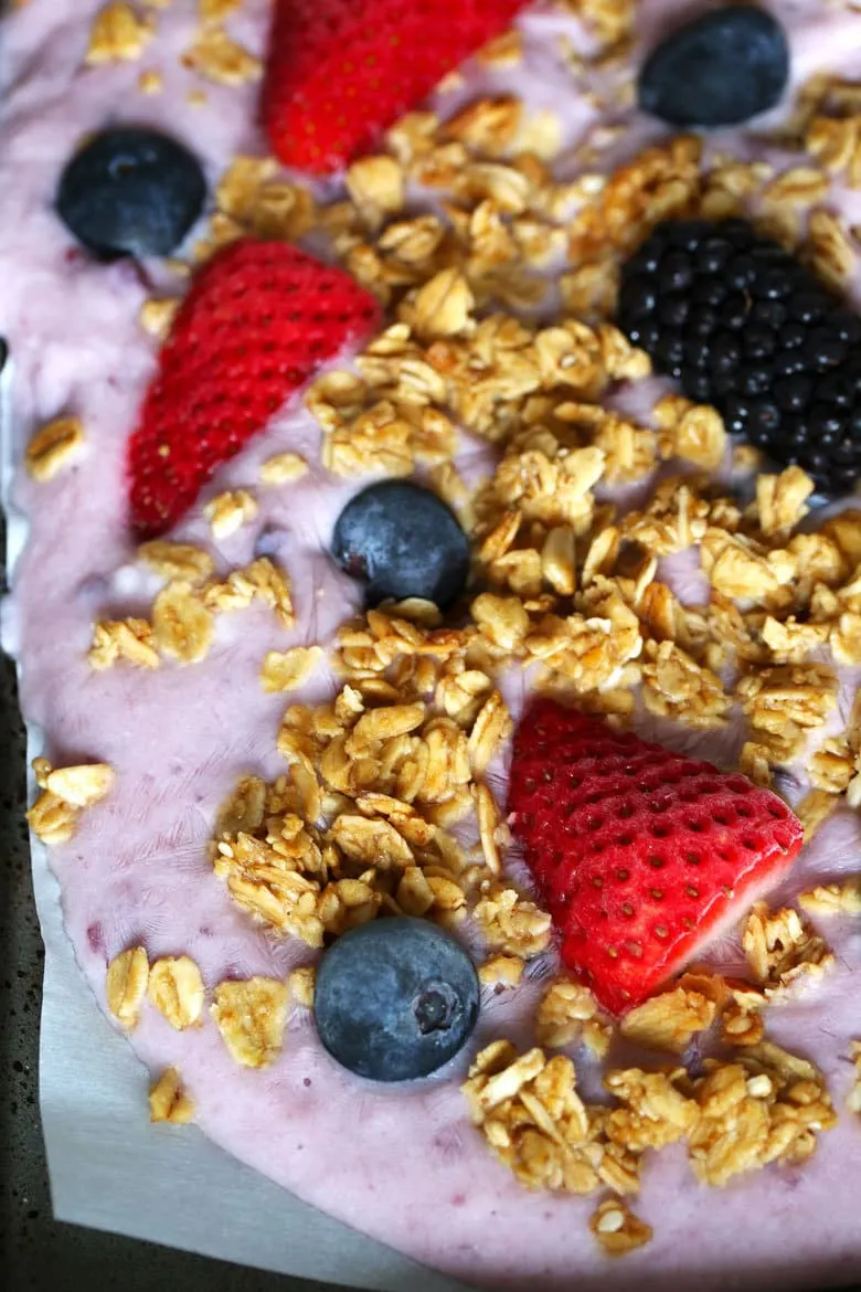 This triple berry granola frozen yogurt breakfast bark is perfect for busy mornings. It's like eating a make-ahead breakfast parfait popsicle and is great for feeding a crowd! Uncracked bark up close.