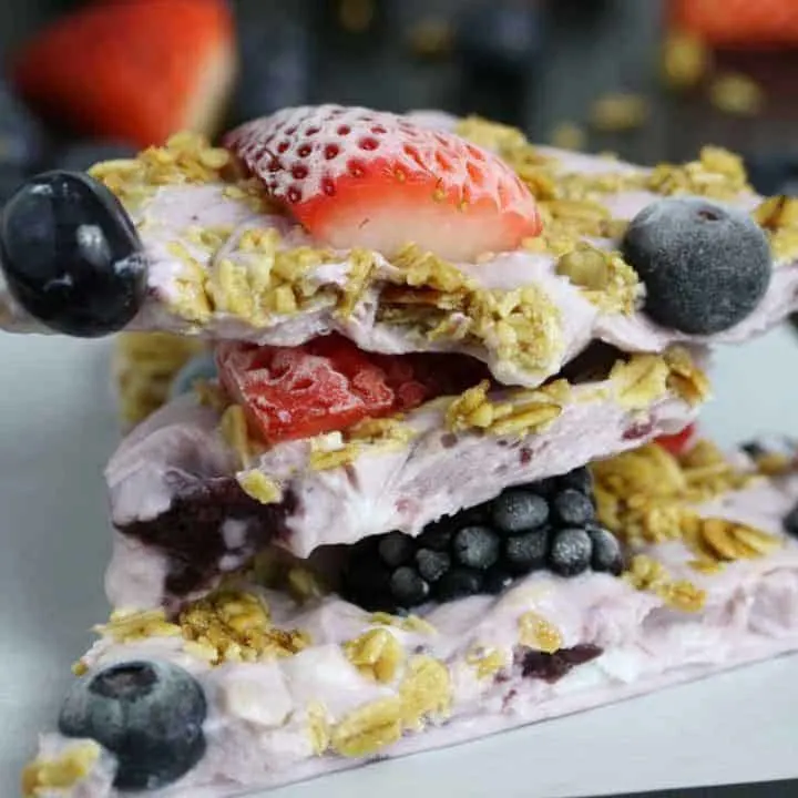 This triple berry granola frozen yogurt breakfast bark is perfect for busy mornings. It's like eating a make-ahead breakfast parfait popsicle and is great for feeding a crowd! Bark up close