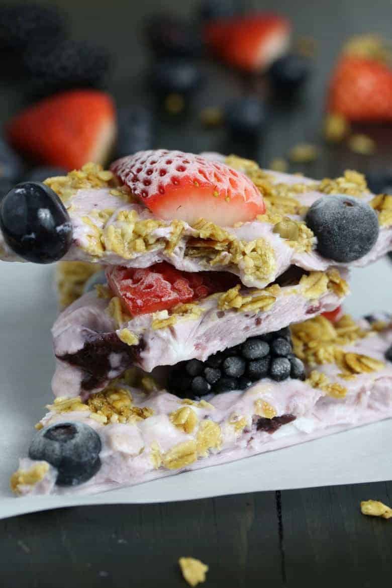 This triple berry granola frozen yogurt breakfast bark is perfect for busy mornings. It's like eating a make-ahead breakfast parfait popsicle and is great for feeding a crowd! Bark up close