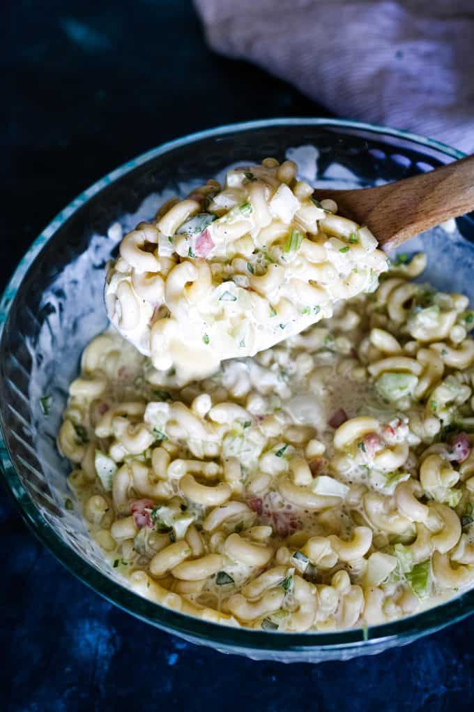 deli style macaroni salad on a wooden spoon