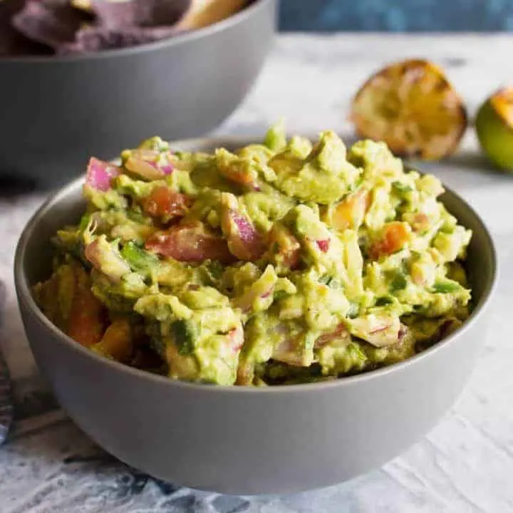 This grilled guacamole recipe is going to be your new favorite summer dip. Grilling all of the vegetables gives the guacamole a smoky and unforgettable taste.