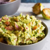 This grilled guacamole recipe is going to be your new favorite summer dip. Grilling all of the vegetables gives the guacamole a smoky and unforgettable taste.