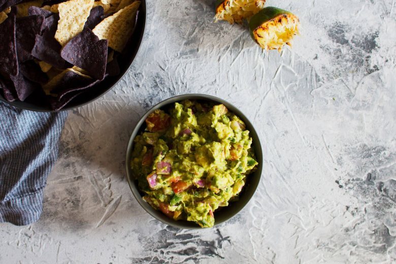 This grilled guacamole recipe is going to be your new favorite summer dip. Grilling all of the vegetables gives the guacamole a smoky and unforgettable taste.