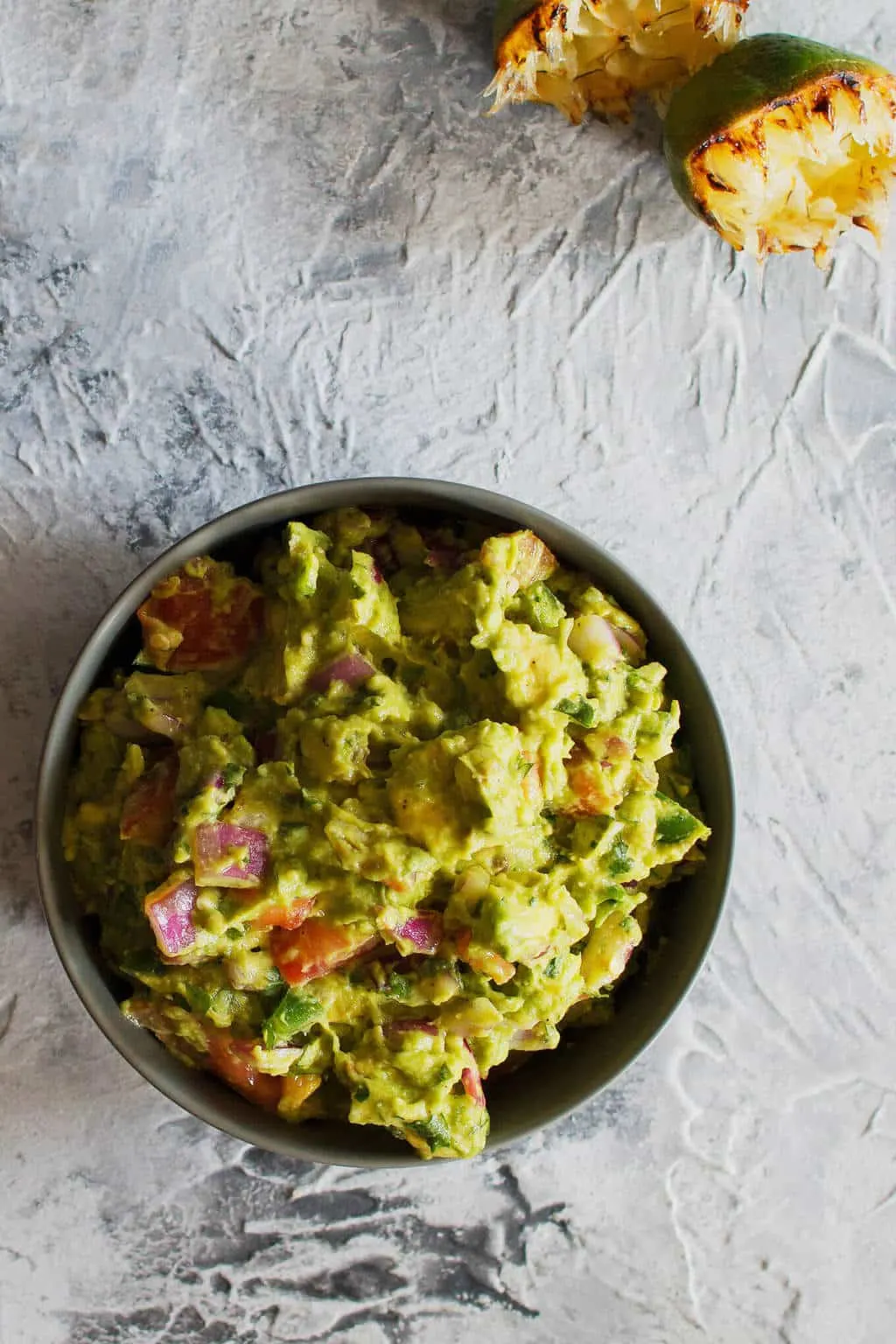 This grilled guacamole recipe is going to be your new favorite summer dip. Grilling all of the vegetables gives the guacamole a smoky and unforgettable taste.