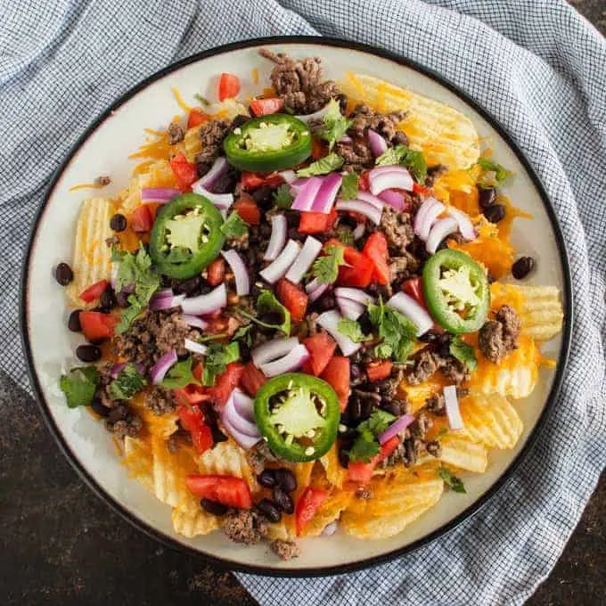 Last-minute tailgating party? Make these easy potato chip nachos with all of your favorite toppings! This is going to become your favorite game day food.