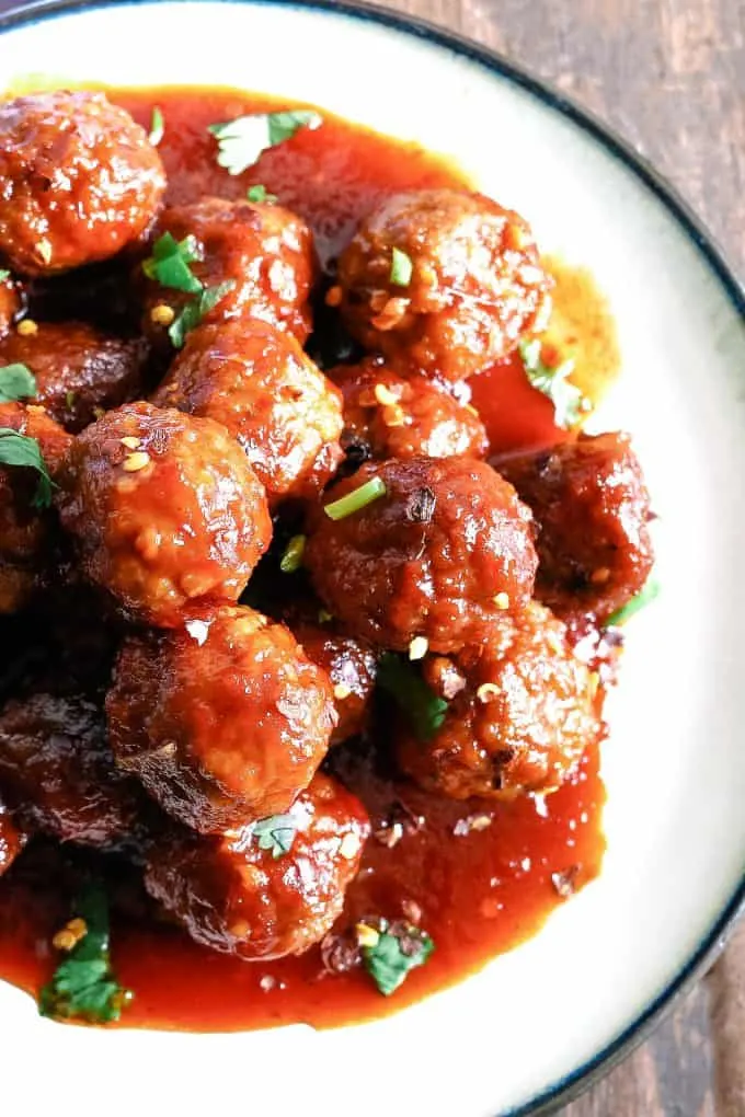 slow cooker sweet and spicy meatballs on a white plate