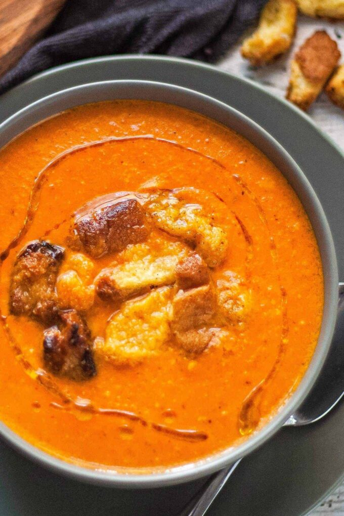 bowl of brie and roasted red pepper soup with brioche croutons