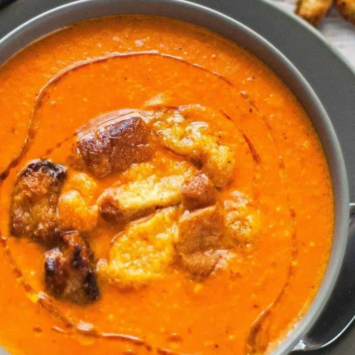 bowl of brie and roasted red pepper soup with brioche croutons