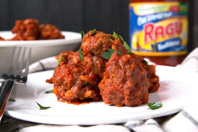 meatballs on a plate with bowl of meatballs in background