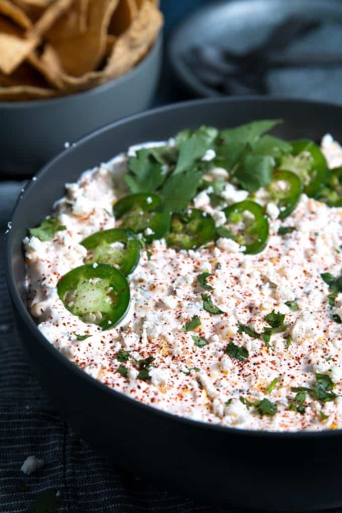 corn dip topped with jalapenos and cilantro