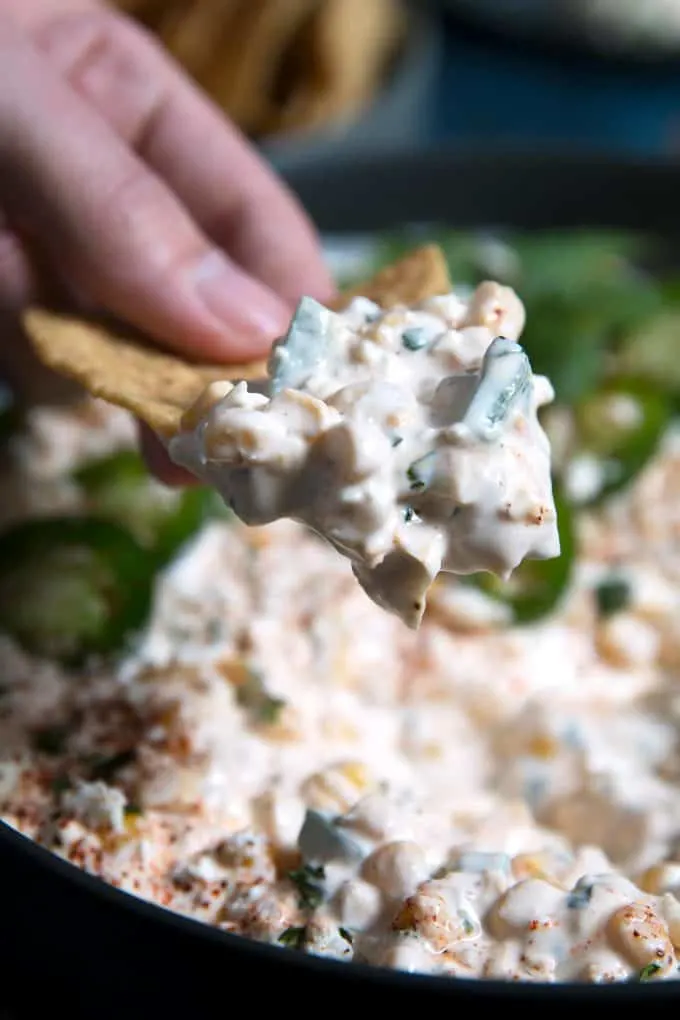 corn dip on a chip being held by a hand