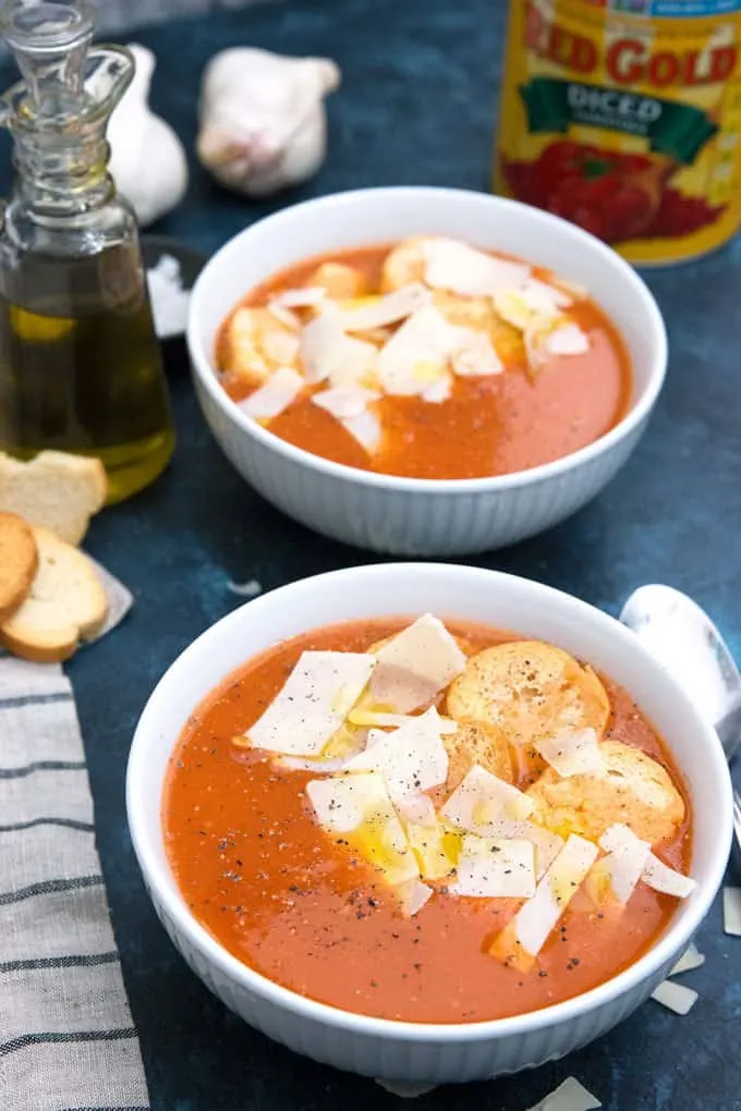 roasted garlic tomato soup garnished with croutons, parmesan cheese and olive oil