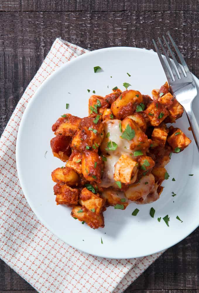 one pan cheesy gnocchi on a plate with a fork and napkin