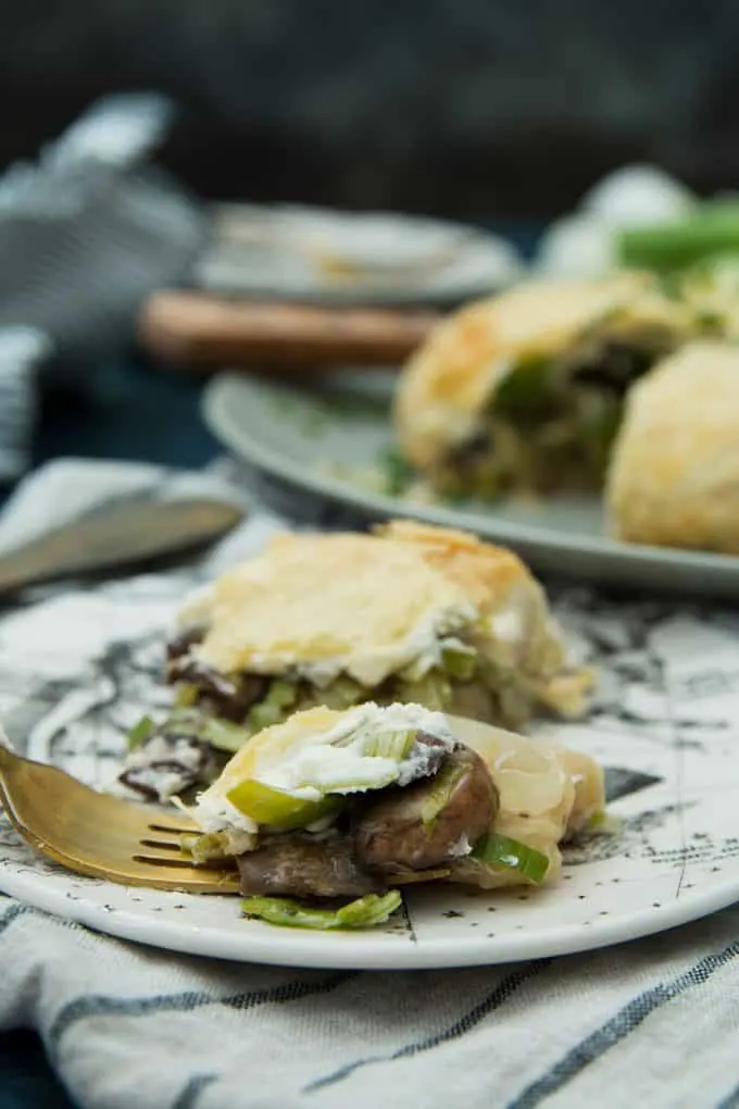 slice of leek mushroom cheese stuffed puff pastry being eaten