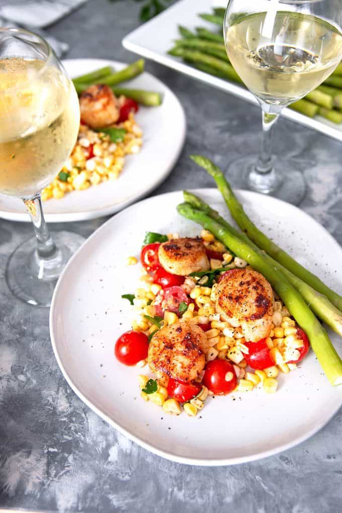 seared garlic scallops with two glasses of white wine