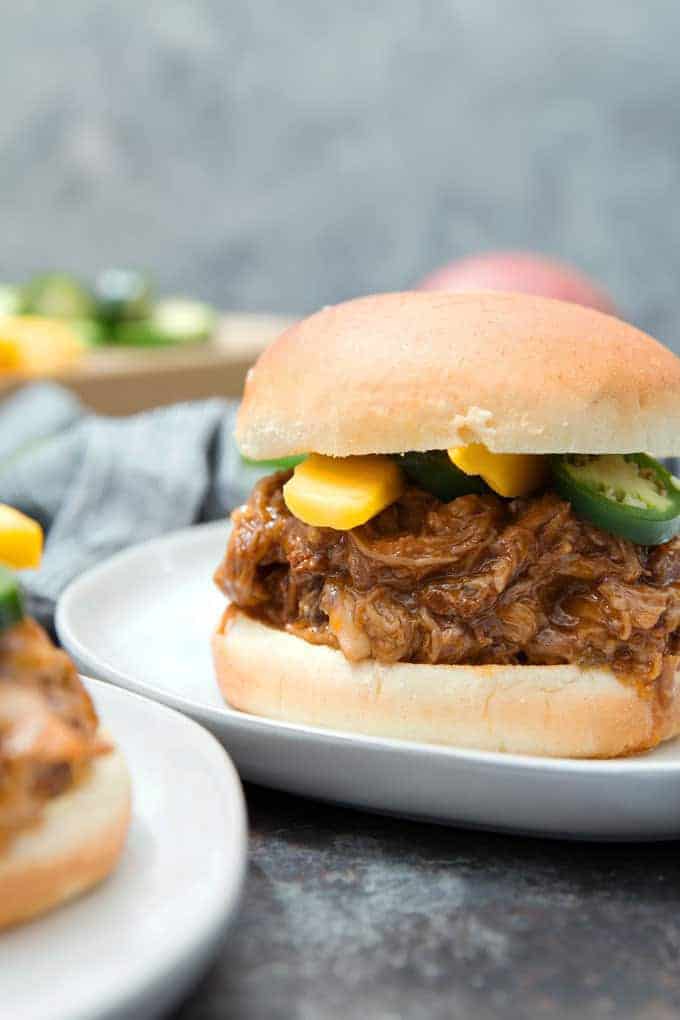 mango pulled pork sandwich on a white plate