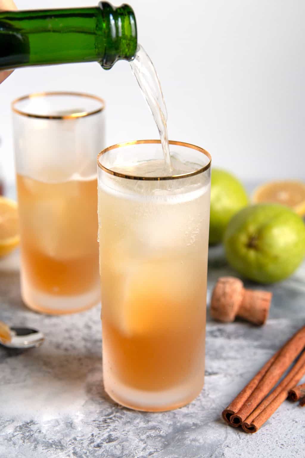 sparkling wine being poured into the sparkling bourbon pear cocktail