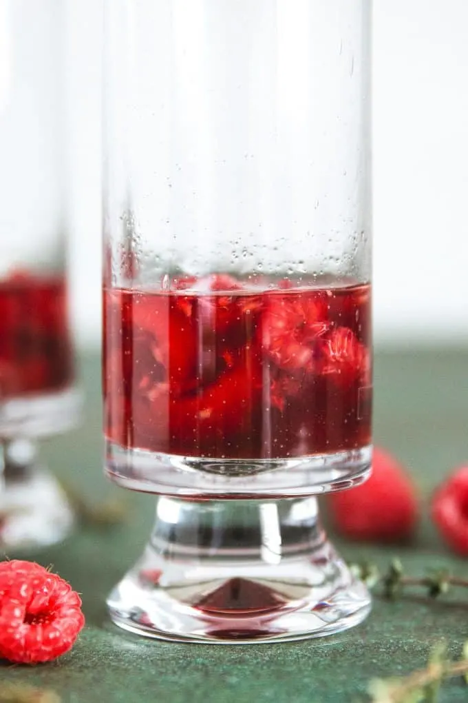 smashed raspberries in a glass with Chambord