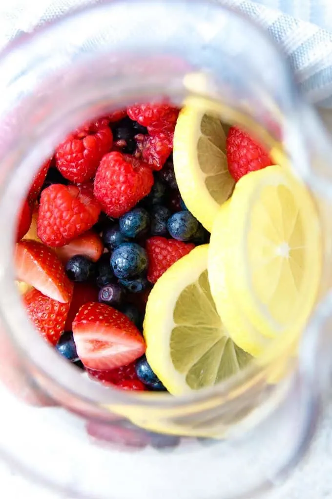 berries and lemon slices in a pitcher