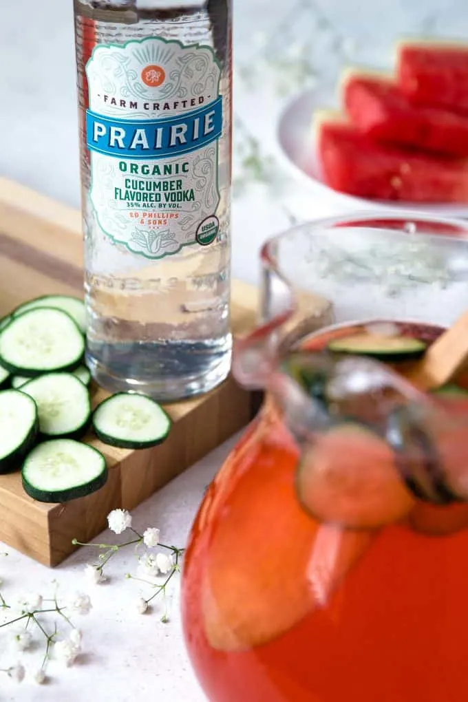 bottle of Prairie Organic Spirits cucumber vodka with a pitcher of cucumber watermelon punch