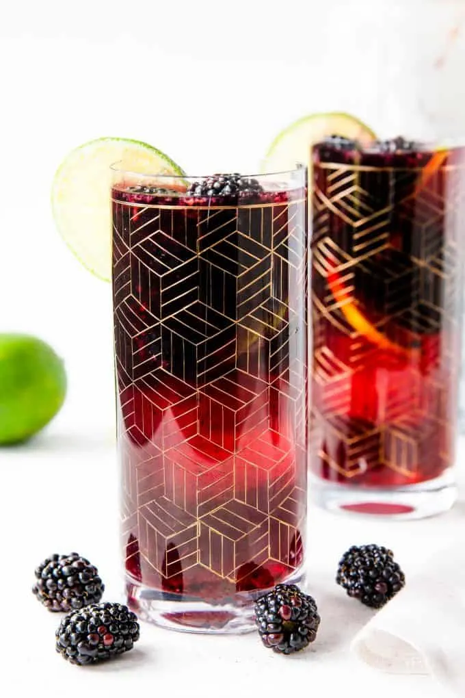 two gold etched glasses of blackberry sangria
