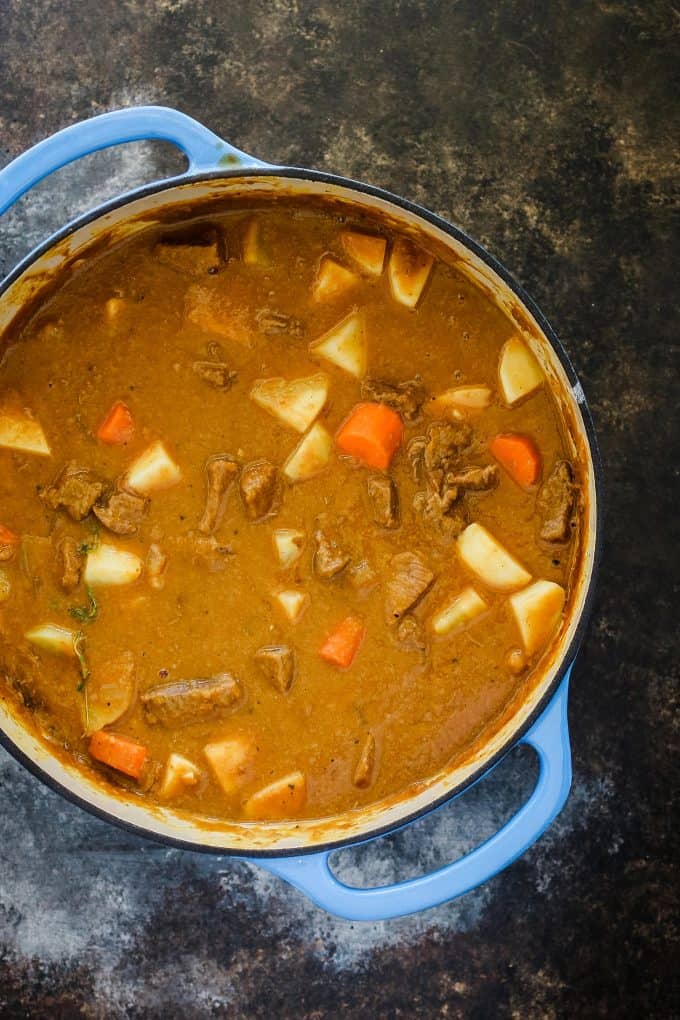 blue dutch oven filled with pumpkin beef stew