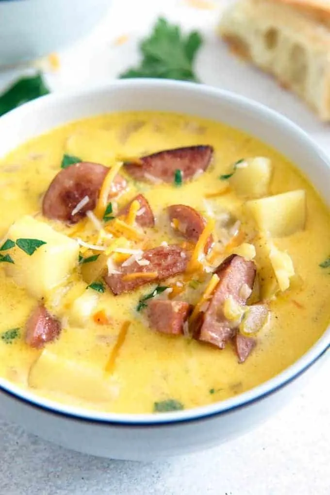 potato kielbasa soup in a white bowl with a blue rim