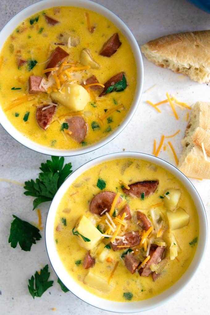 2 bowls of potato kielbasa soup with chunks of crusty bread