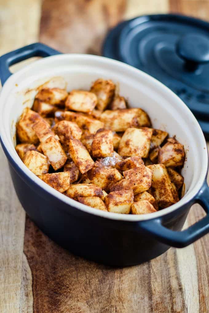 baked apple slices fresh out of the oven in a black mini cocotte