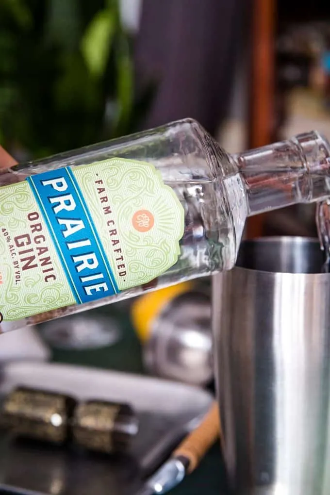 pouring Prairie Organic Spirits gin into a cocktail shaker