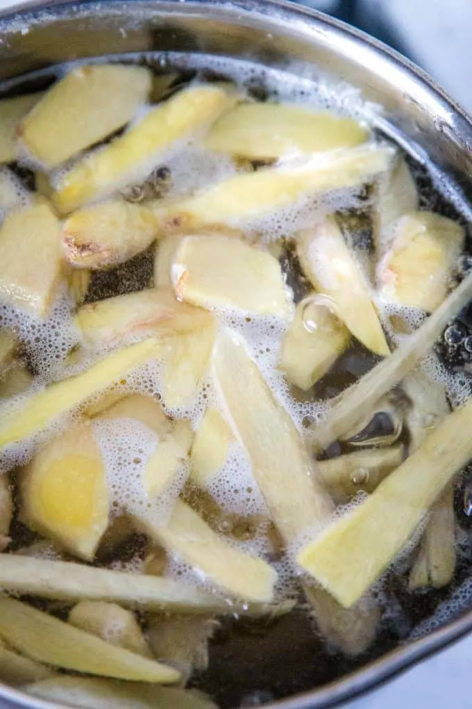 ginger boiling in a pot of distilled water and sugar