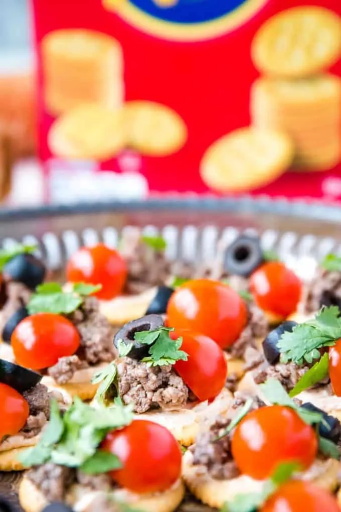 RITZ cracker topped with seasoned cream cheese and beef, tomato, cilantro, black olive